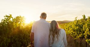 Travel, walking and back with old couple in vineyard for romance, anniversary date and bonding. Sun